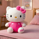 A Hello kitty stuffed animal sitting on a pink bed